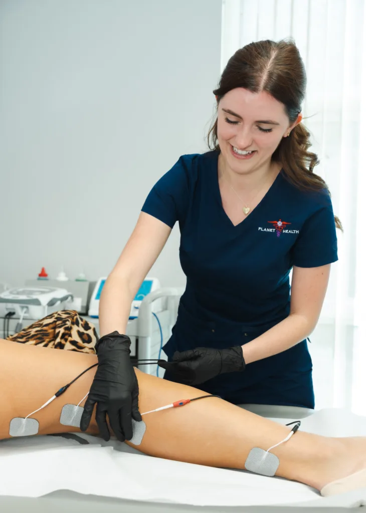 Technician applying electrode pads to a person's leg.